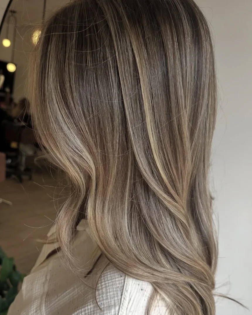 Soft blonde balayage over a natural brunette base at Salon Social